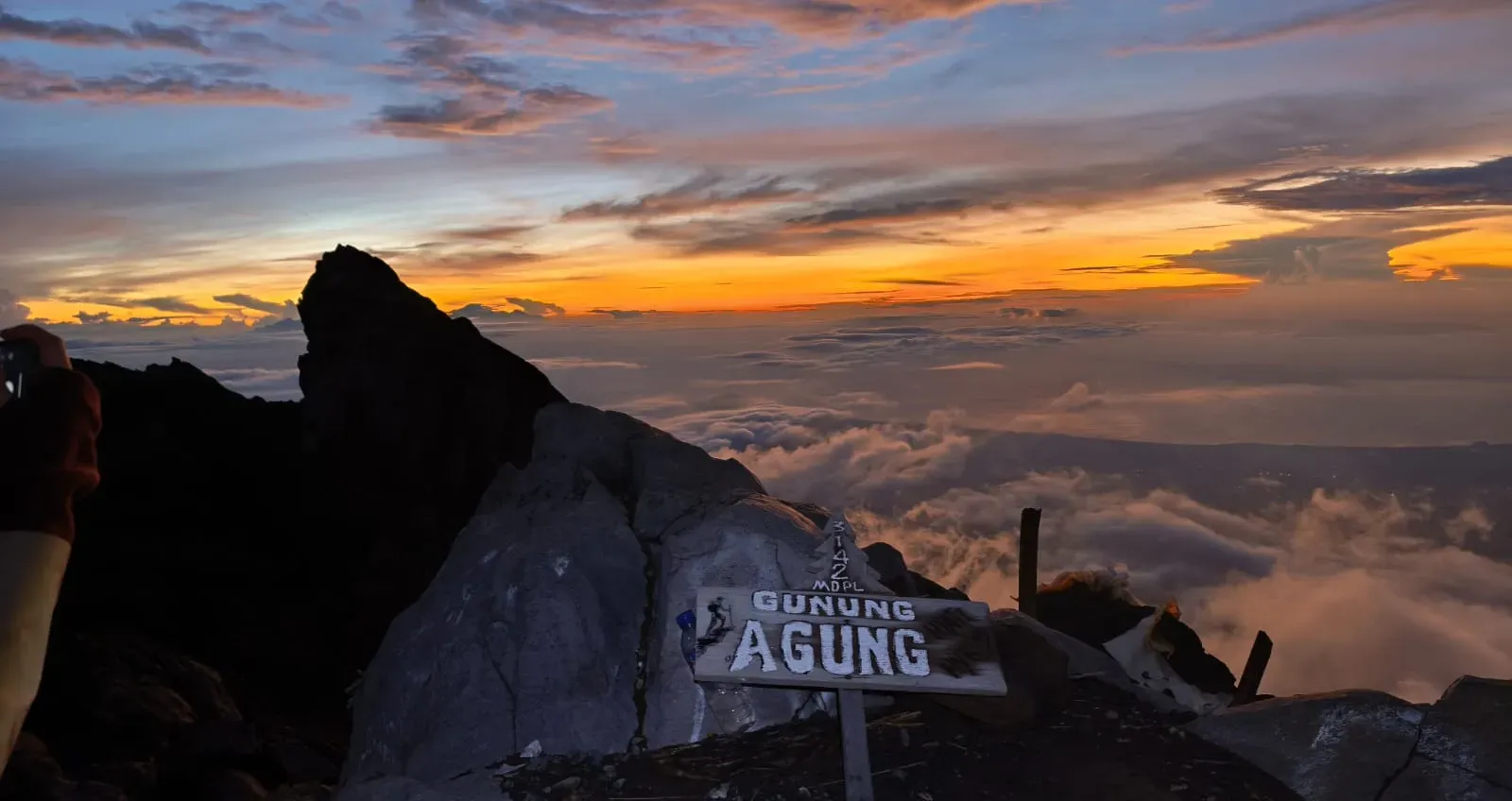 Gunung Agung 3142 MDPL summit sign above a sea of clouds at sunrise