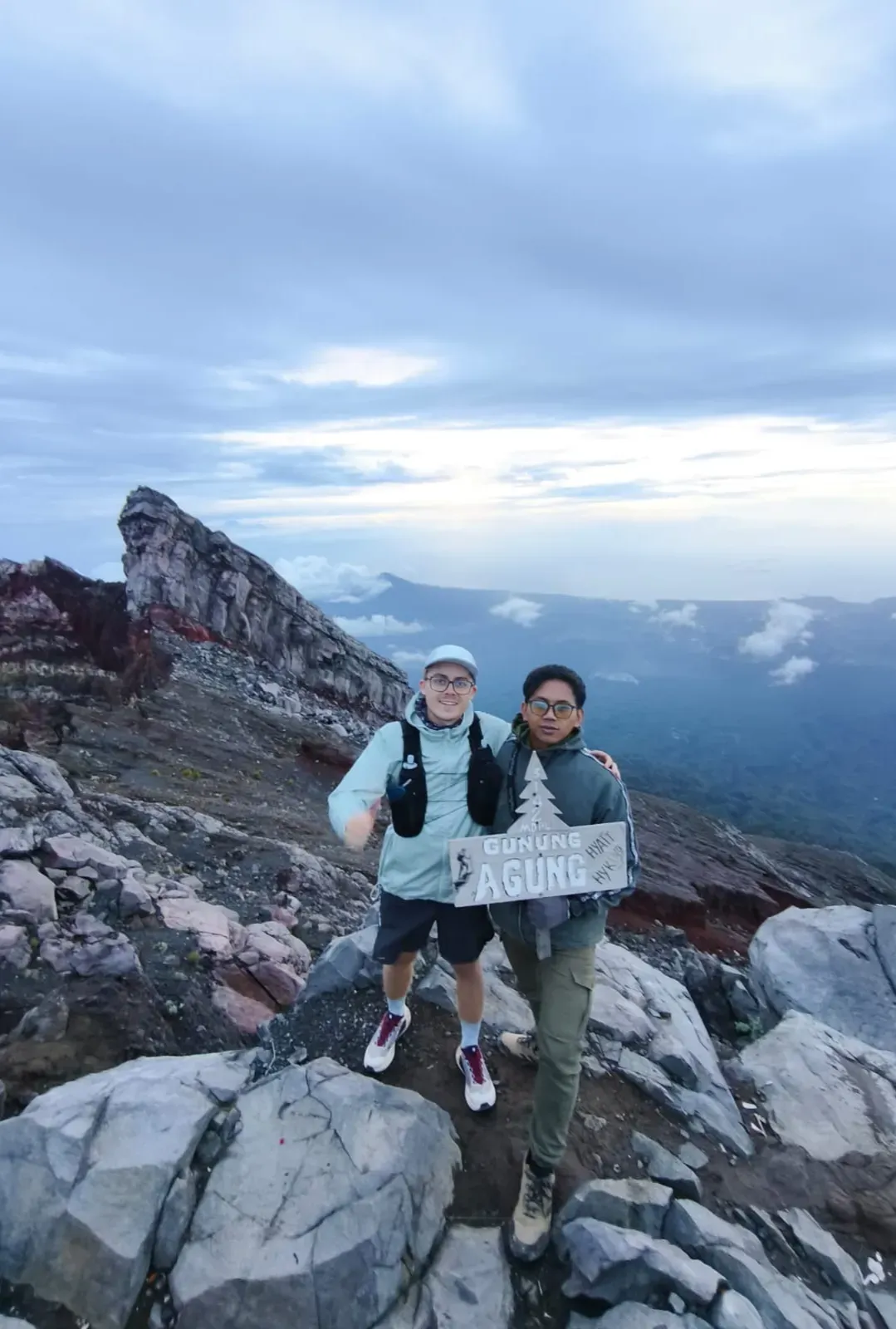 Local Mount Agung guide and trekker with the Gunung Agung summit sign