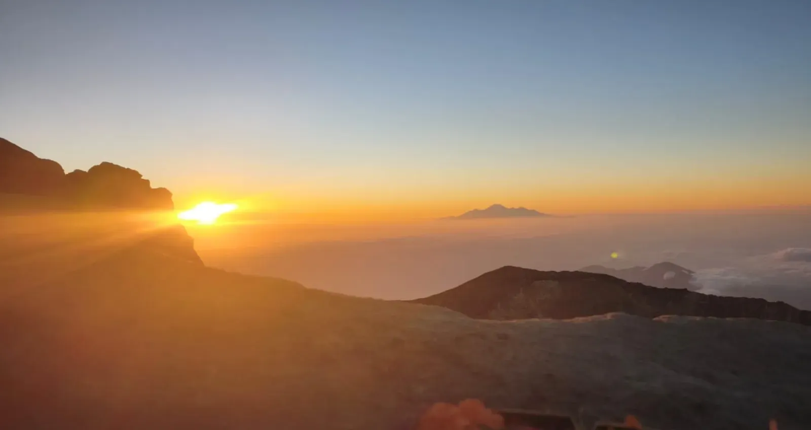 Sunrise light over Mount Agung slopes and distant peaks