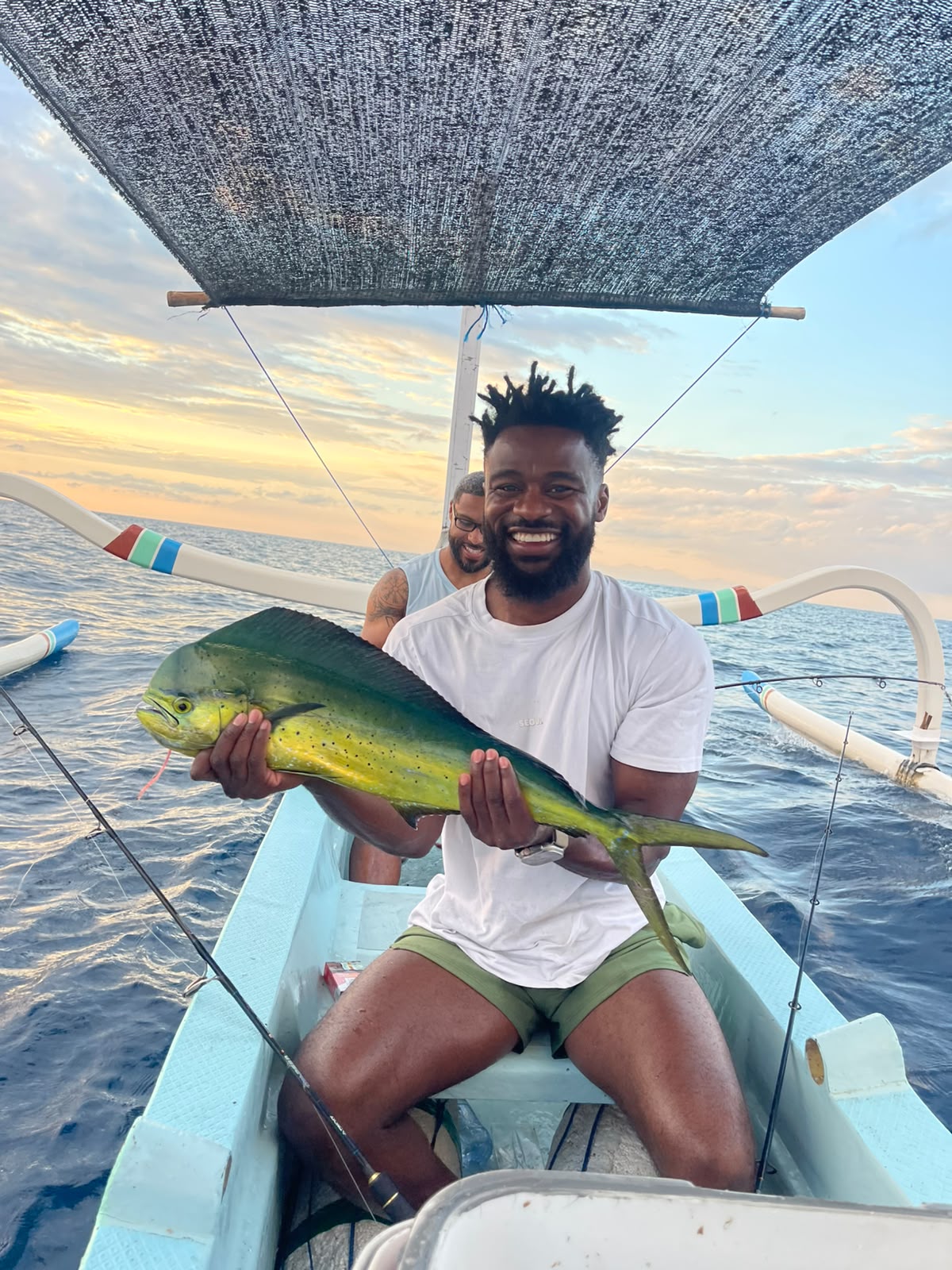 Angler fishing at sunset on traditional boat in Amed waters