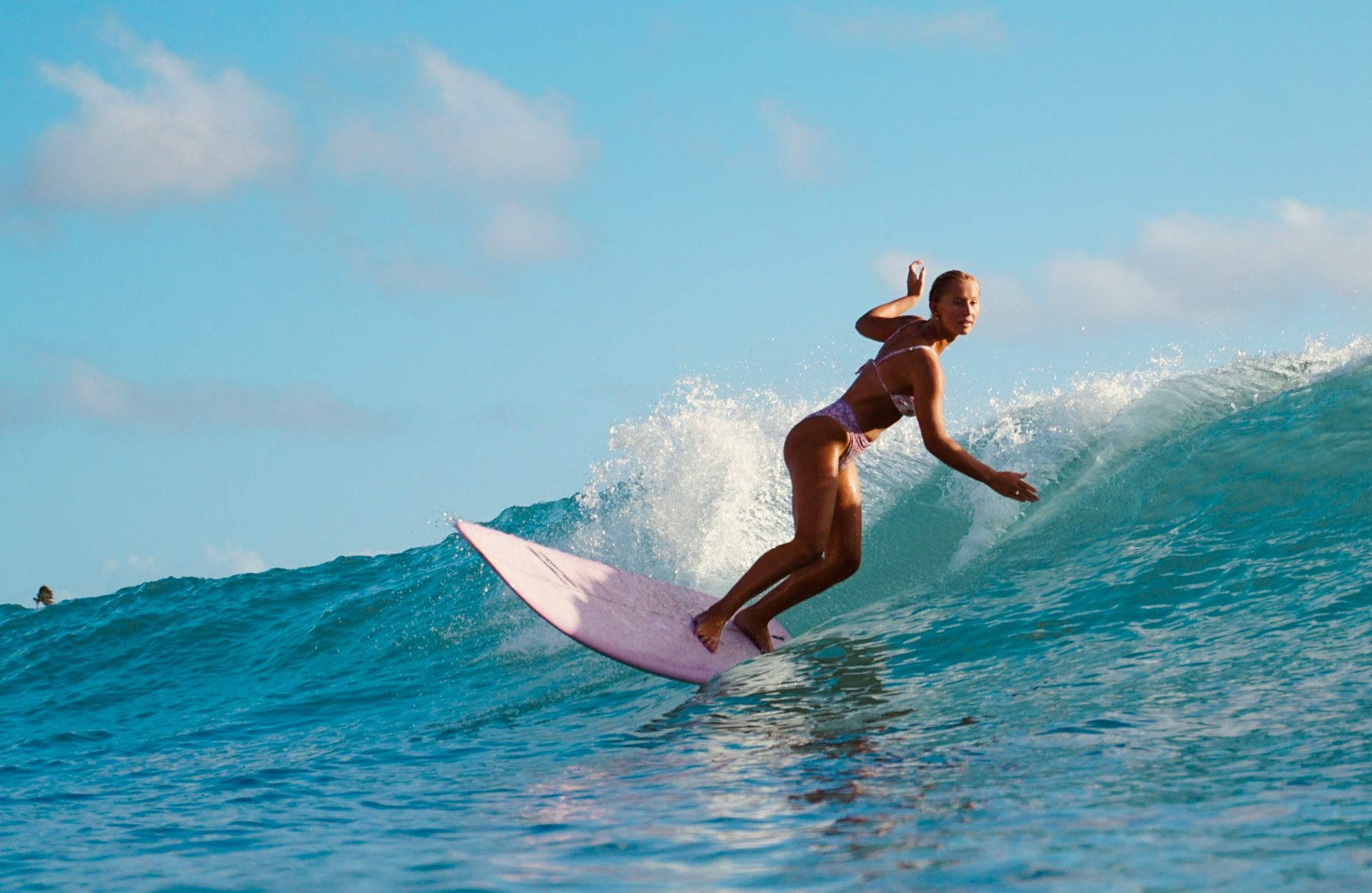Local Balinese surf instructor holding a surfboard on the beach