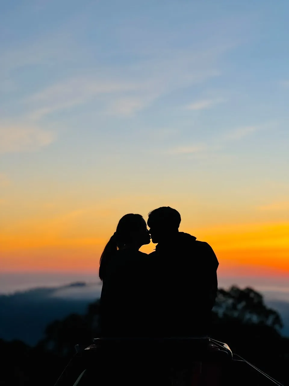 Two guests silhouetted on the jeep at sunrise