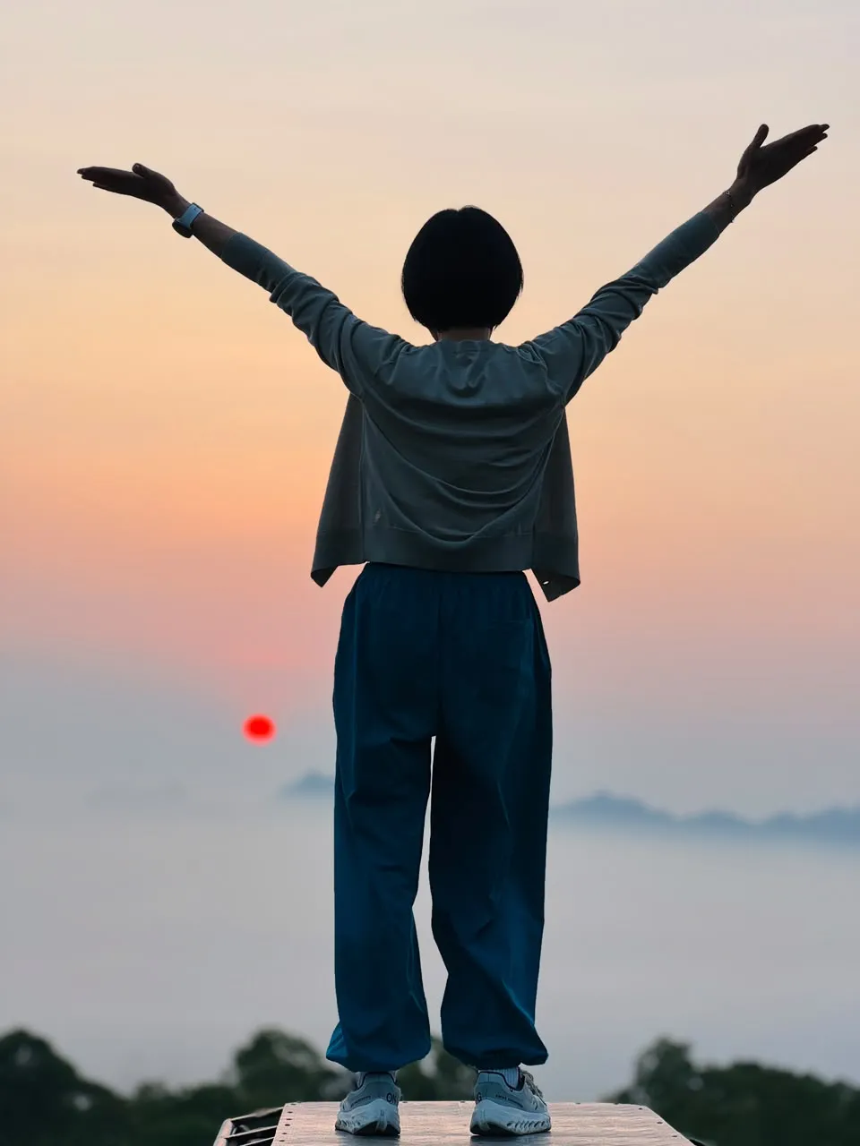 Guest standing on the jeep with arms open at the sunrise stop