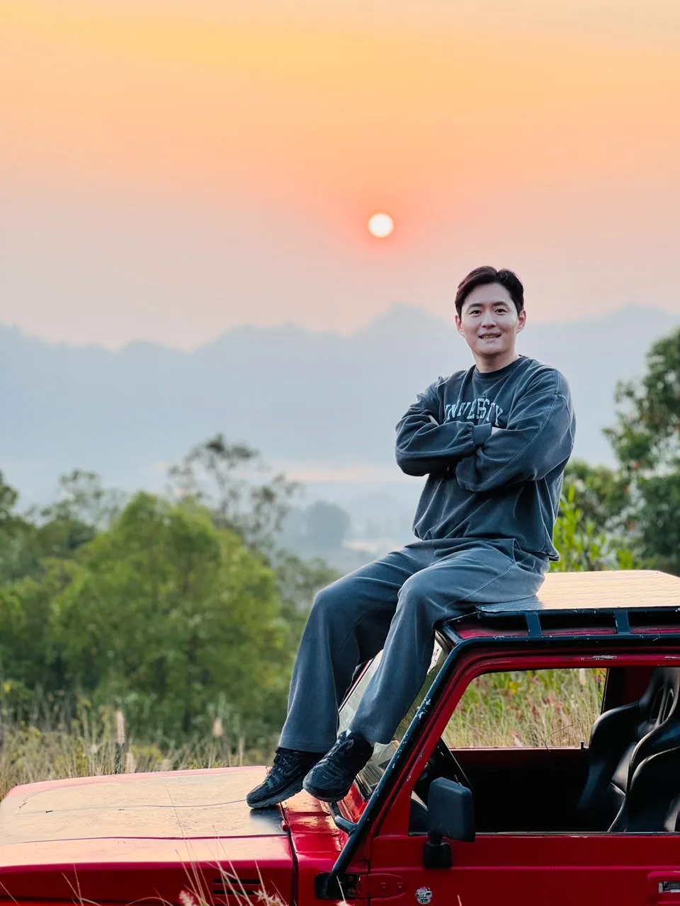 Guest on the red jeep roof at sunrise above the Kintamani hills