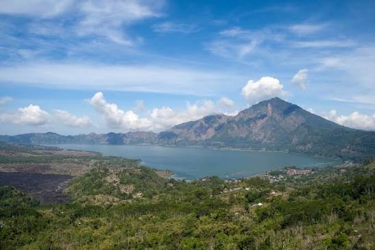 Calm mountain lake surrounded by green highland slopes