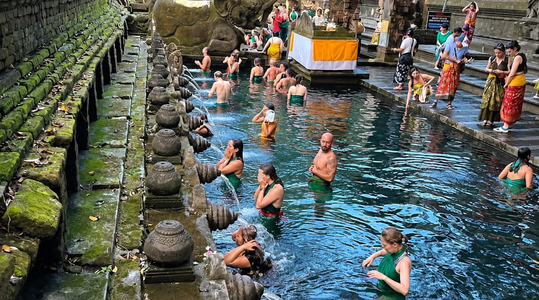 People standing in the long spring pool at Tirta Empul Temple