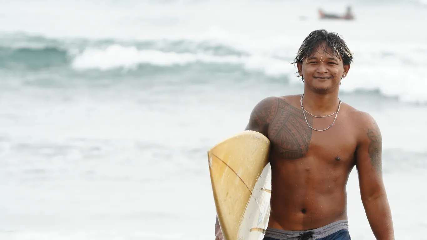 Surfer riding a wave at sunset on a Bali beach