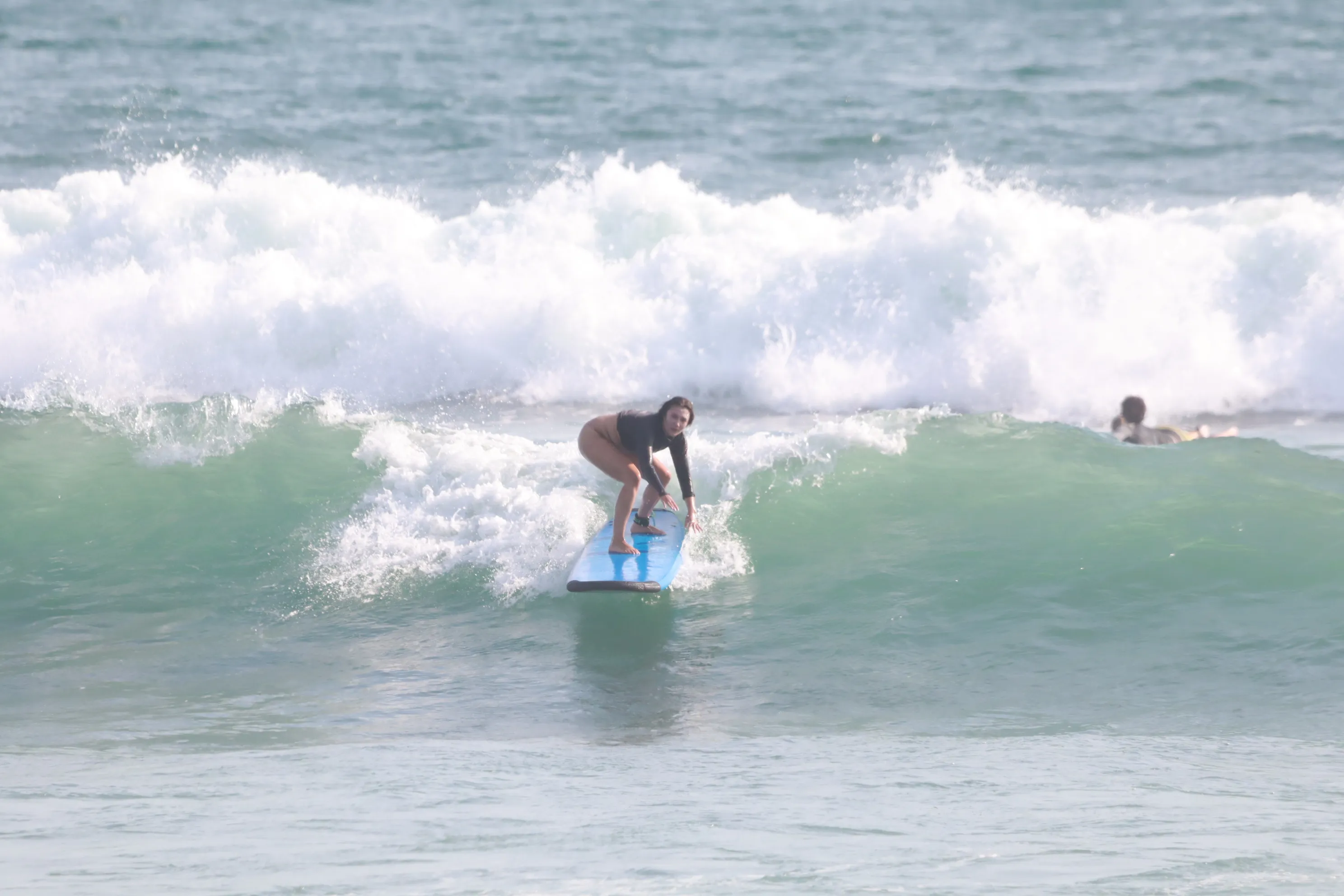 Instructor coaching one beginner surfer