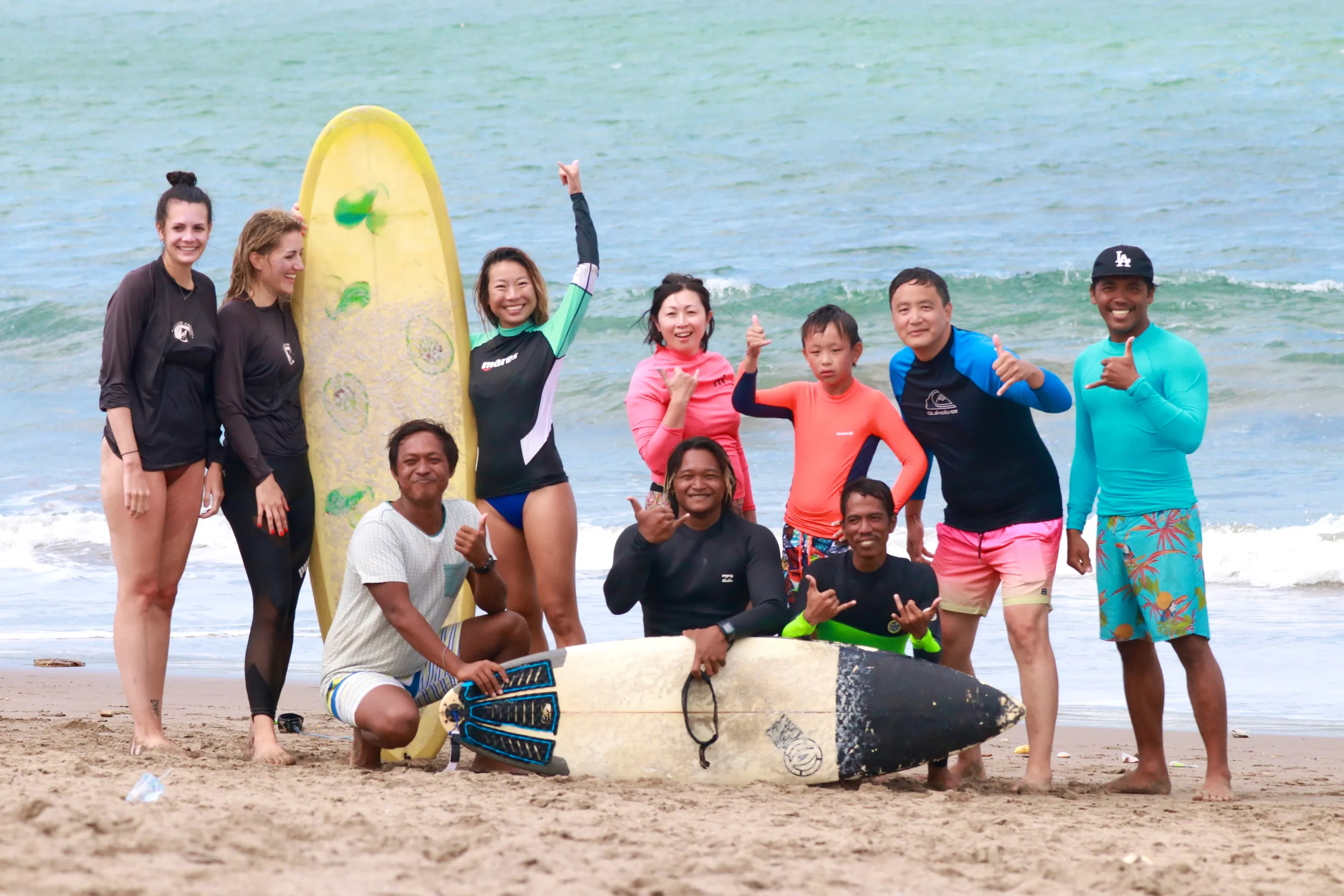 Group of surfers together on the beach