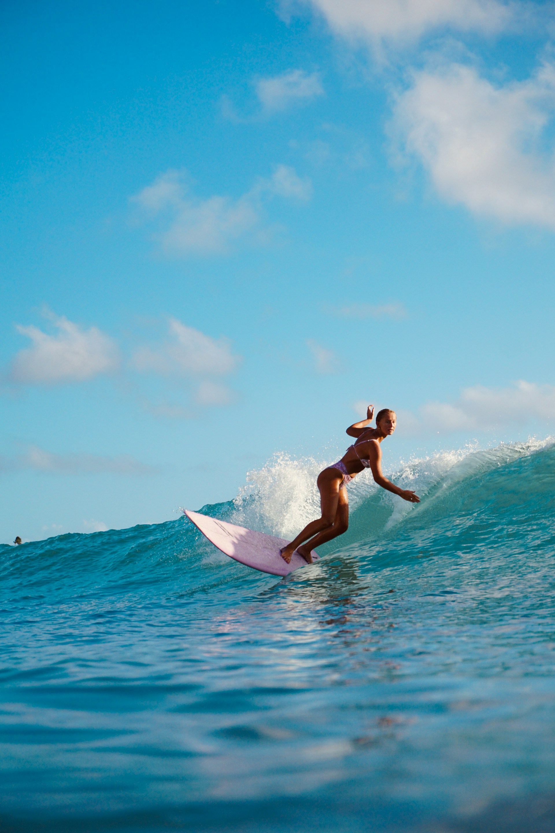 Instruktur surfing mendampingi murid membawa papan di tepi pantai
