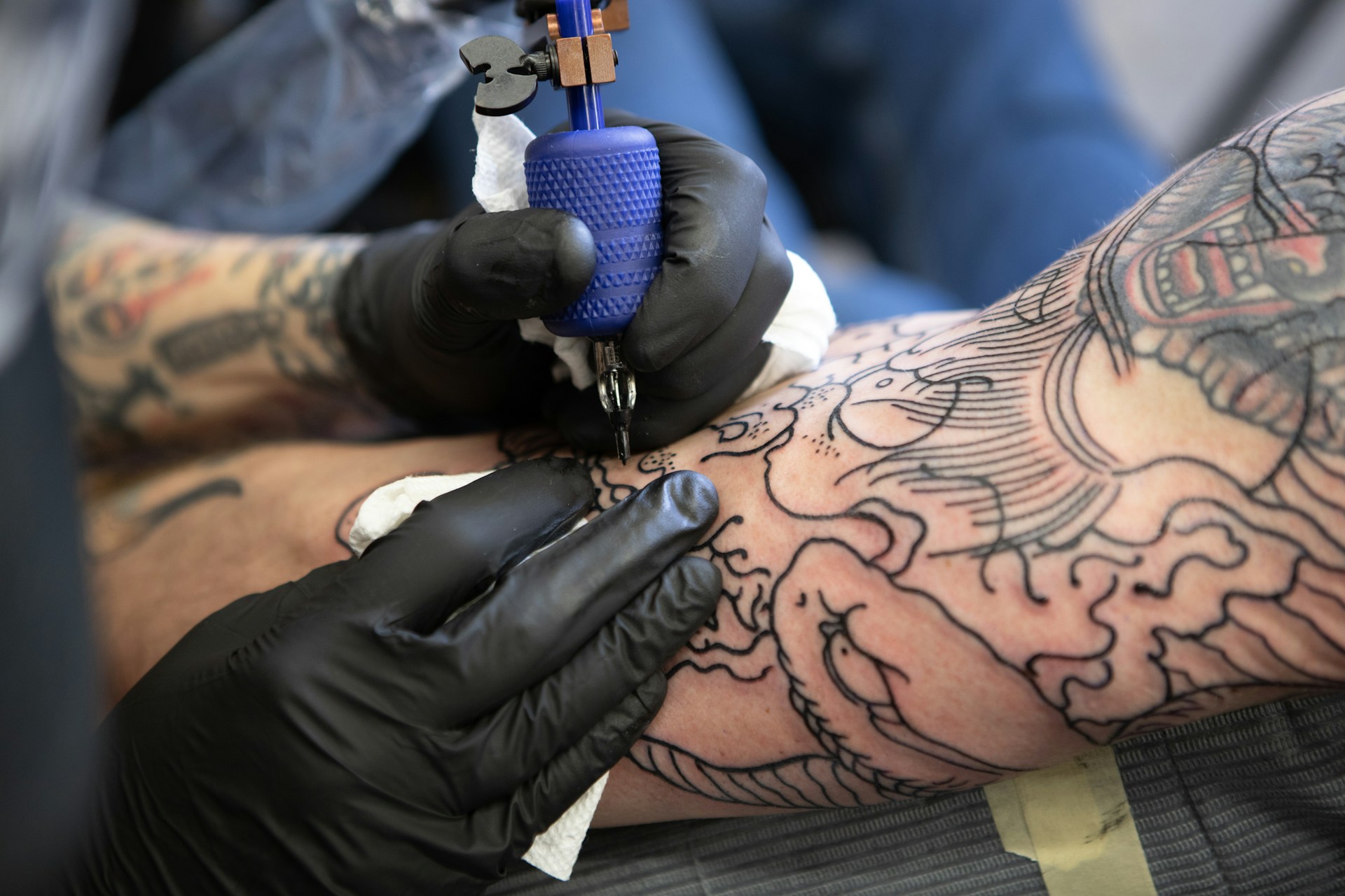 Tangan artis memegang mesin tato