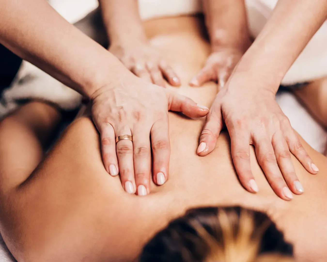 Two therapists giving a synchronized massage