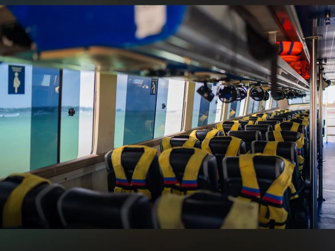 Life jackets on seats beside the windows of a fast boat