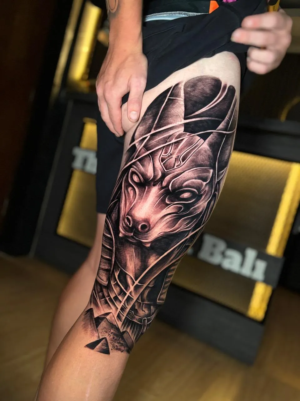 Large realistic Anubis tattoo covering the thigh