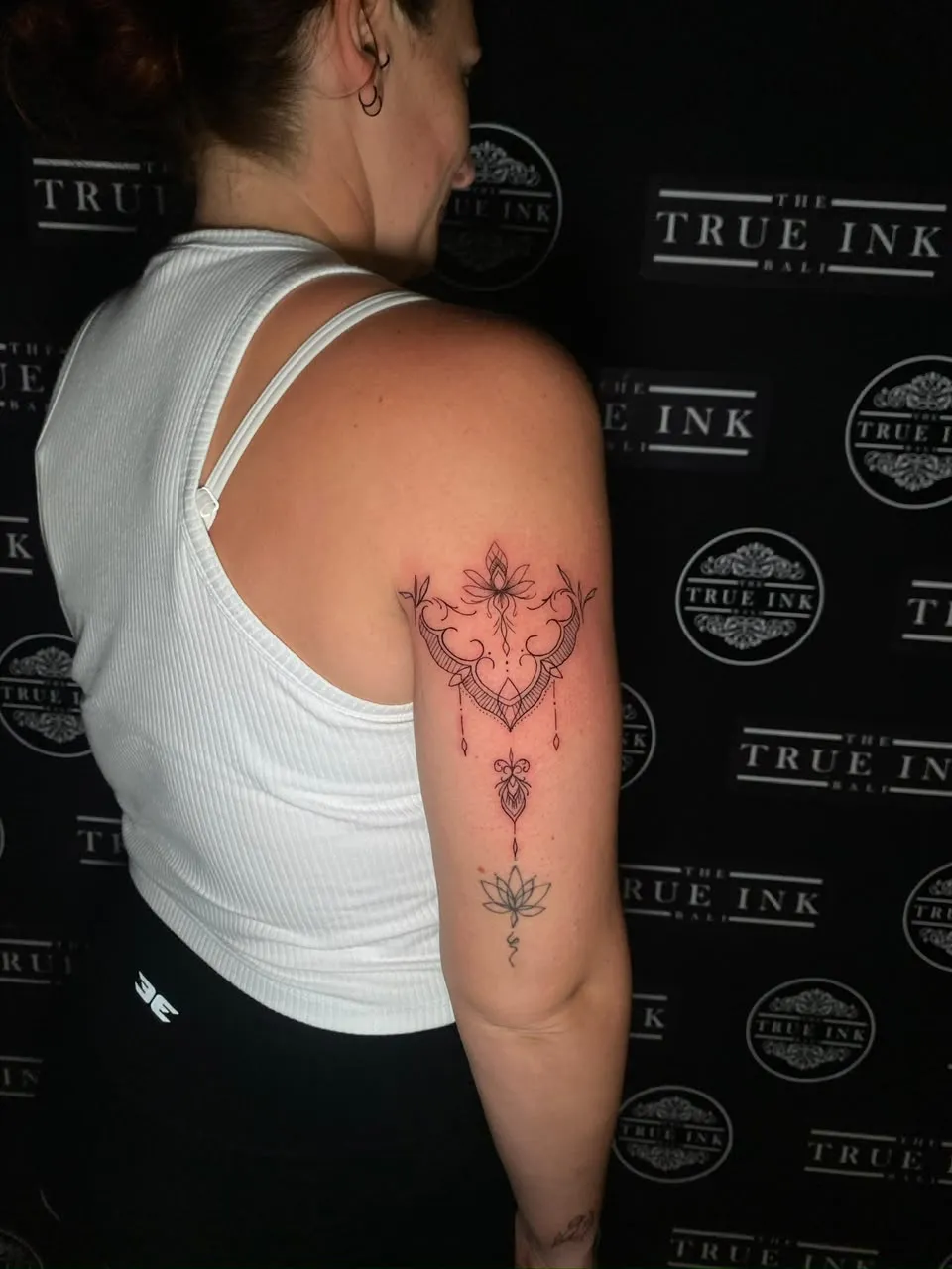 Ornamental fine-line lotus design on the upper arm