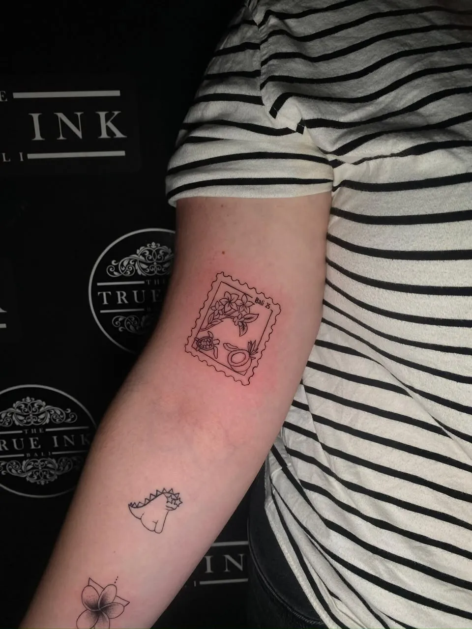 Small fine-line Bali stamp tattoo with turtle, coconut, and flowers