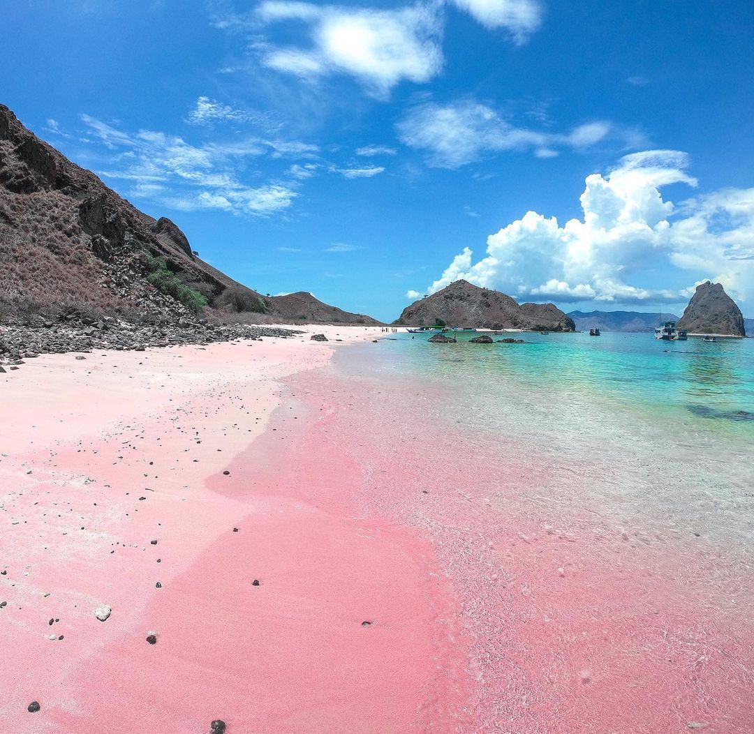 Pantai berpasir kemerahan dengan air laut bening