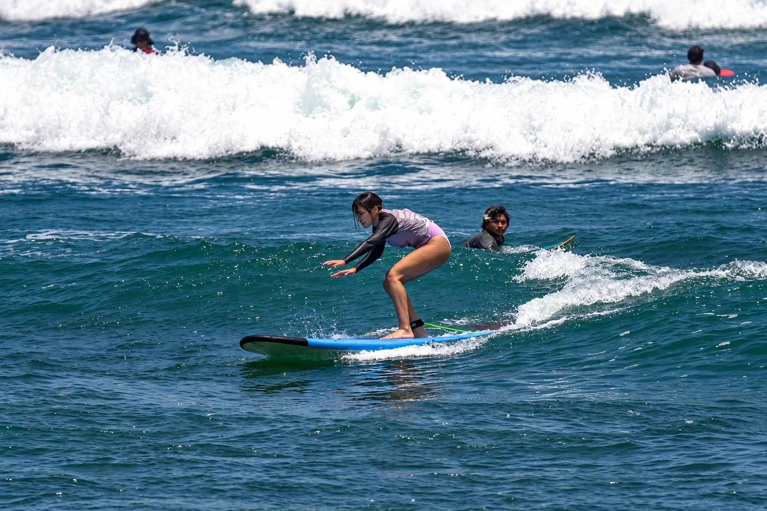 Beginner surf student on a longboard