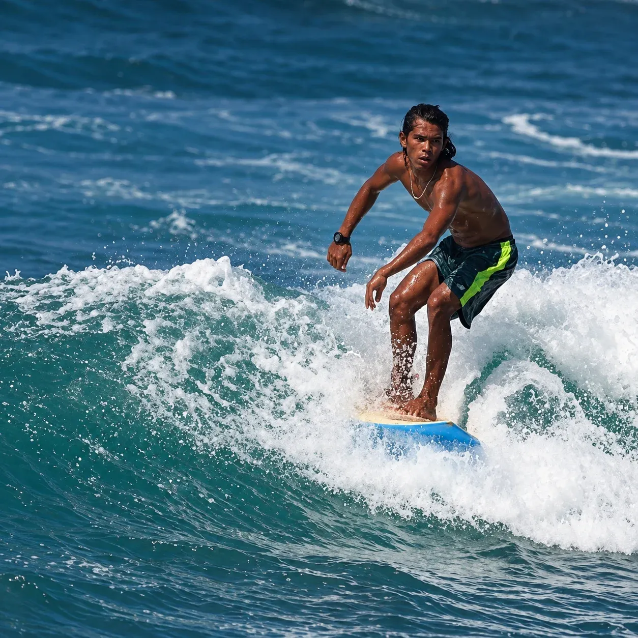 Surfer riding a small wave at a tropical beach