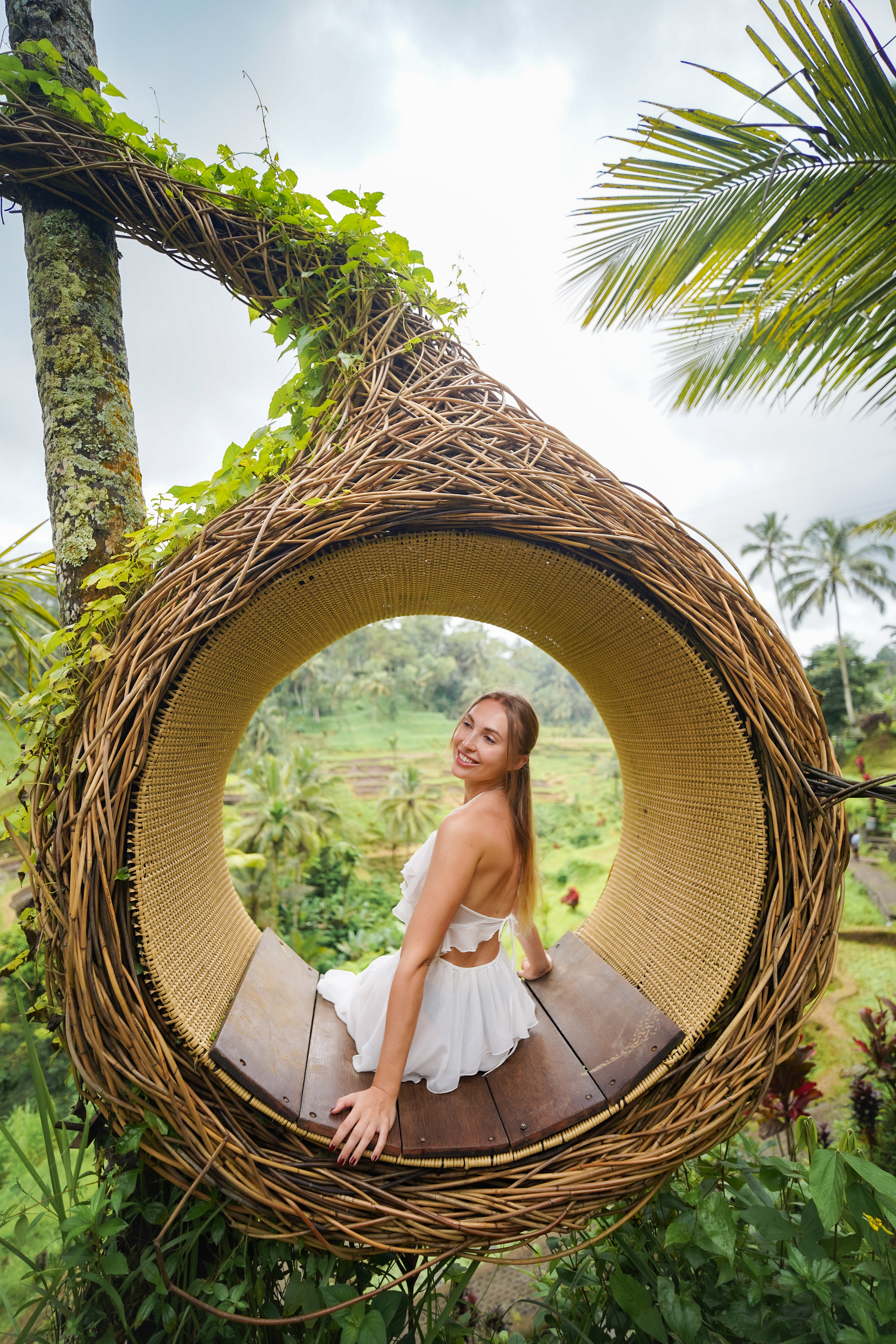 Pasangan berdiri berhadapan saat golden hour di padang rumput Bali
