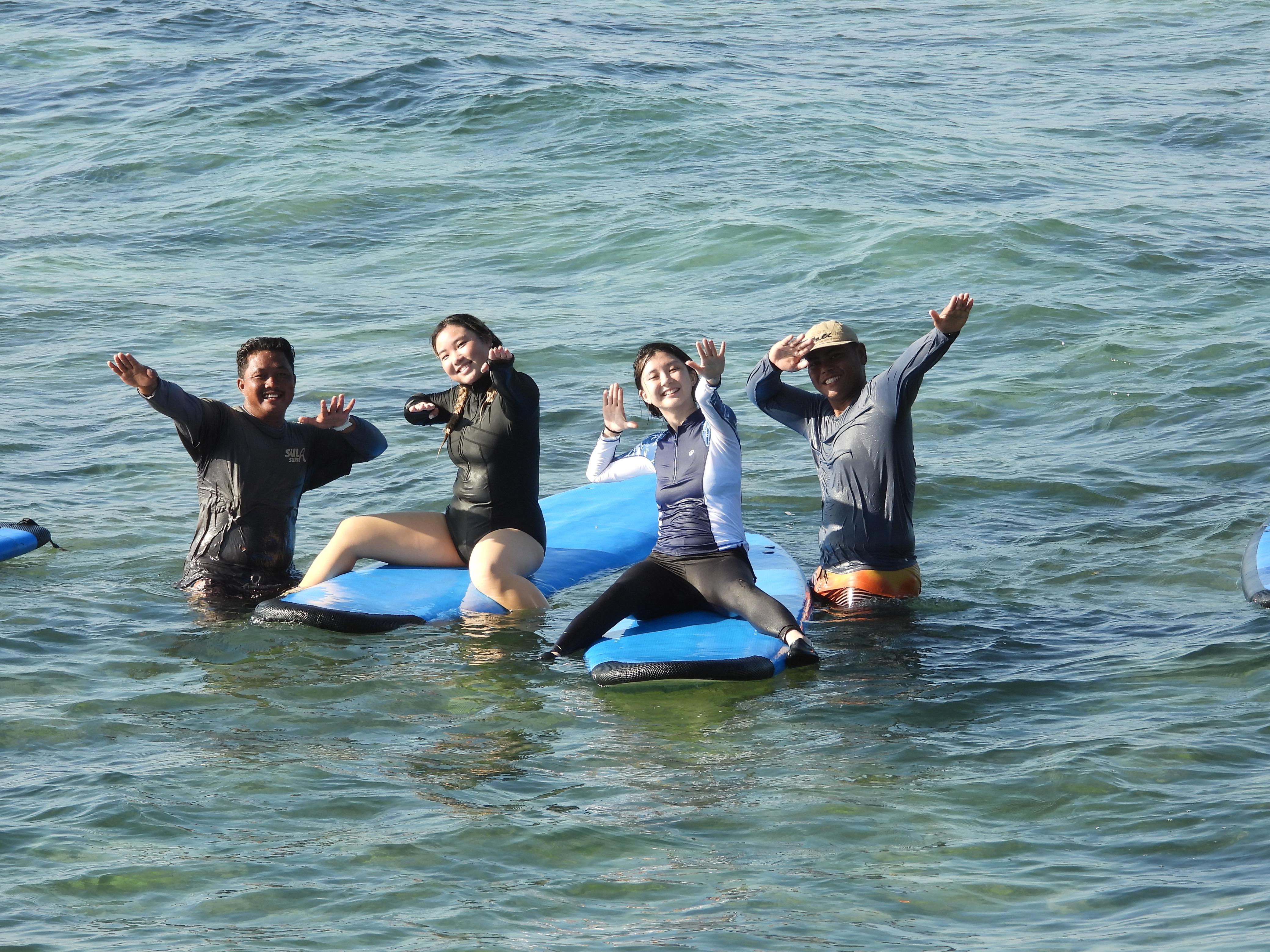 Group surf lesson in Bali with several beginners catching waves together