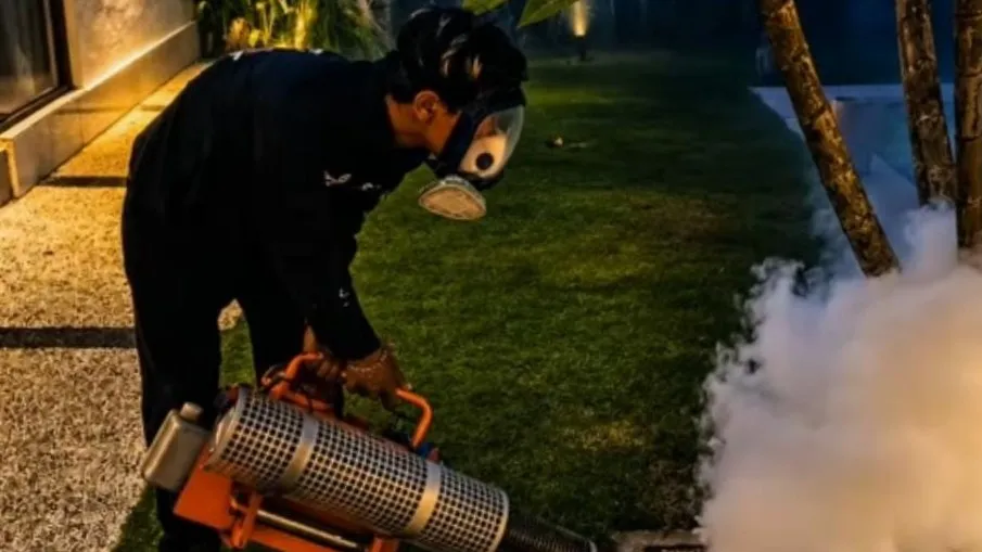Technician treating outdoor plants