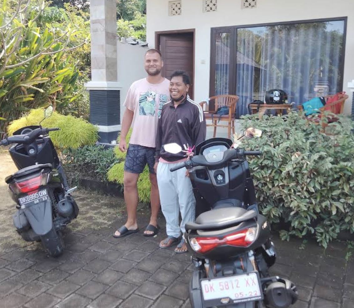 Berkendara scooter menyusuri jalan pedesaan Bali