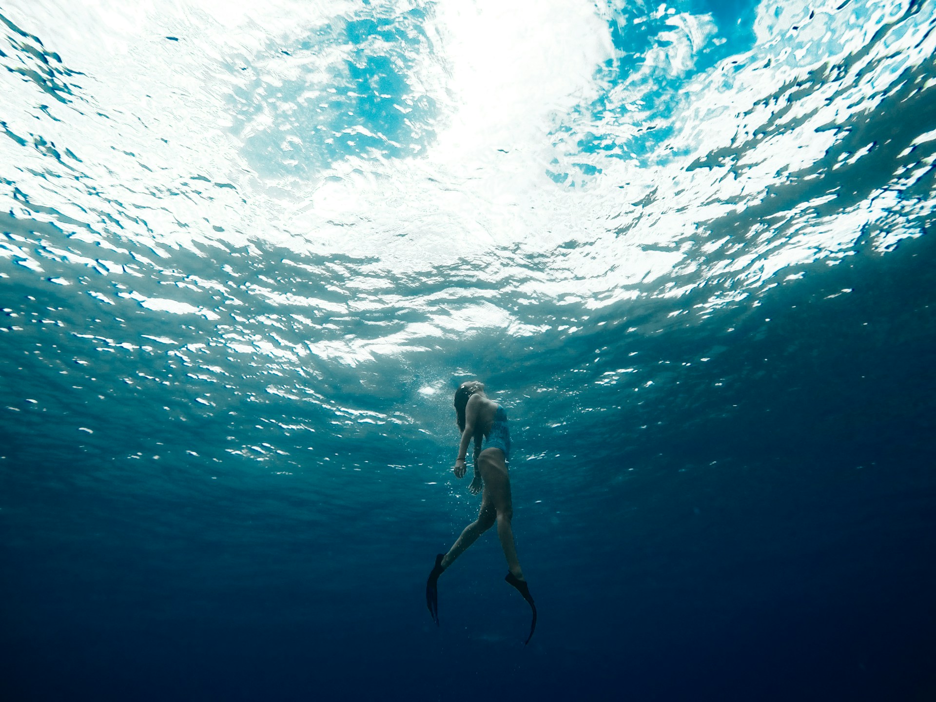 Snorkeler gliding above a vivid coral reef in crystal-clear turquoise water