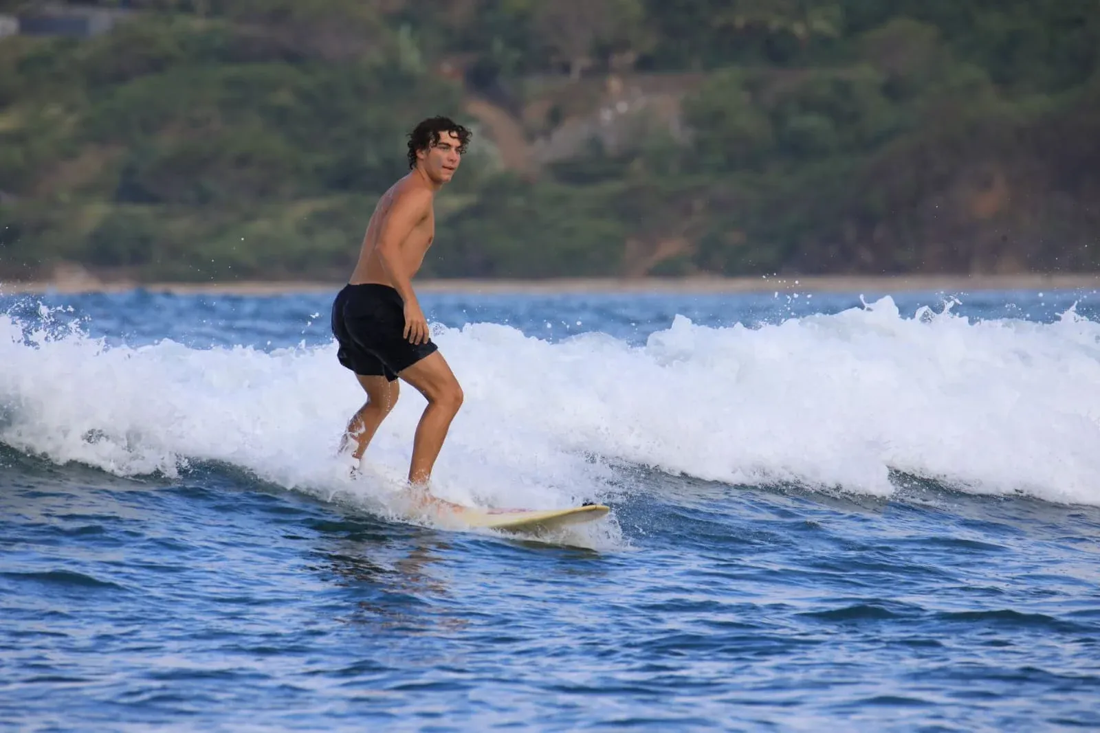 Surfer riding an ocean wave in Lombok