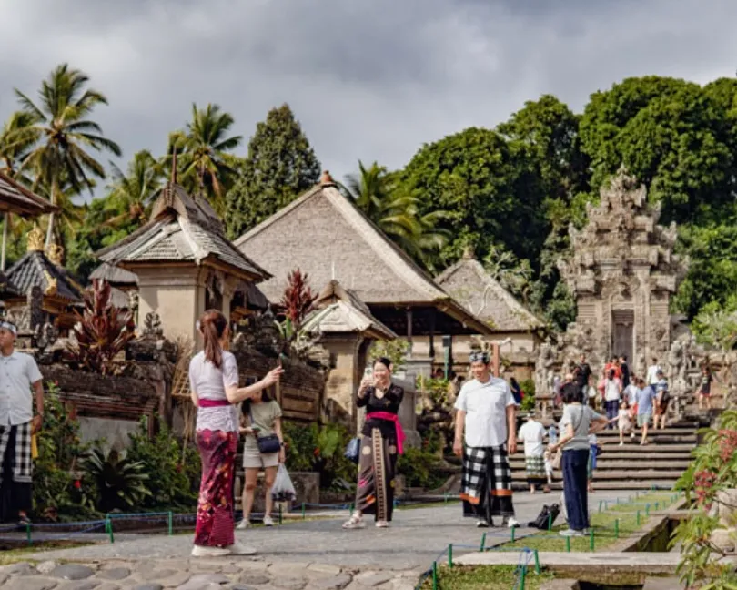 Traditional Balinese village street with temple gates and stone walls