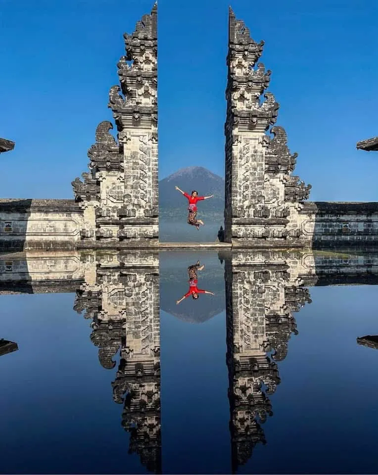 Balinese split temple gate reflected in still water, East Bali