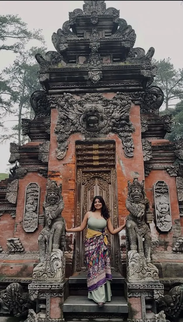 Guest at an ornate Balinese temple gate in Ubud