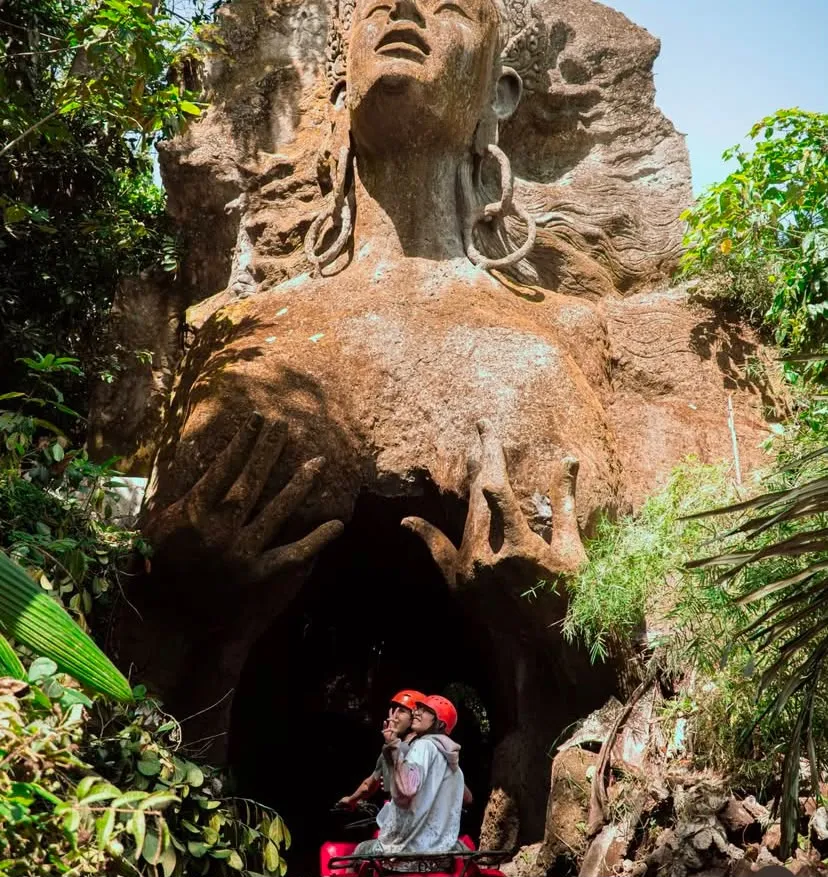 Couple on an ATV riding through a carved cave tunnel