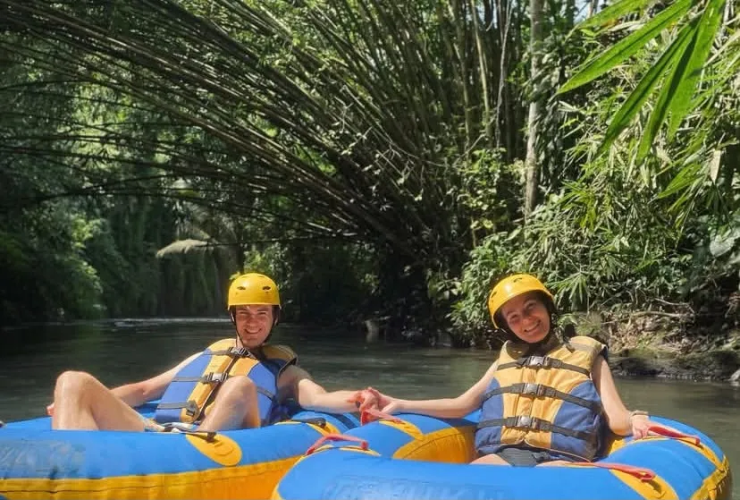 Couple river tubing under bamboo near Ubud