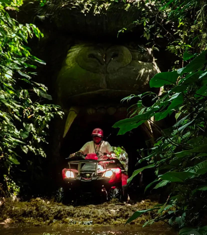ATV riding out of a carved jungle cave tunnel