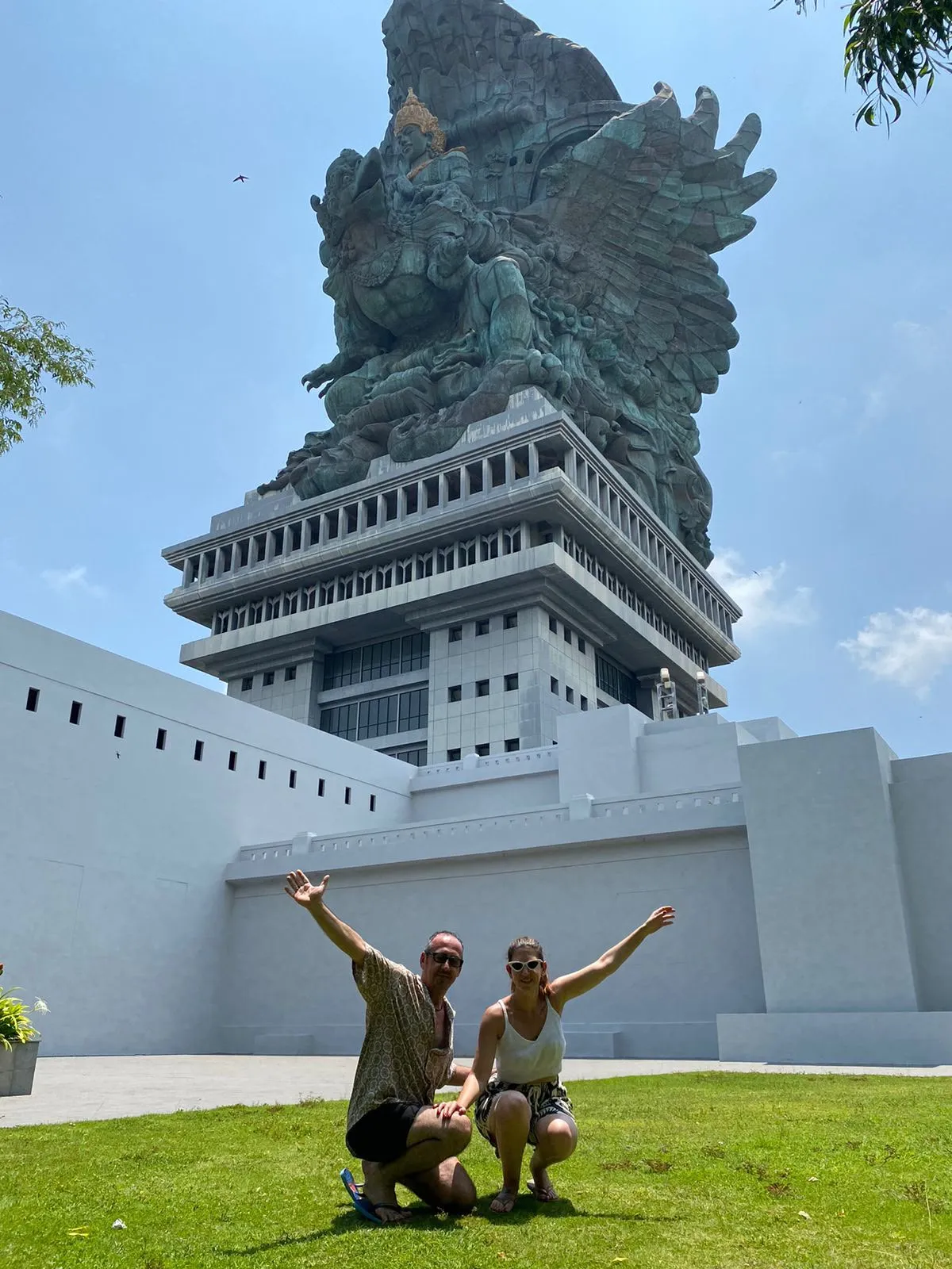 Guests posing below the GWK Garuda Wisnu statue