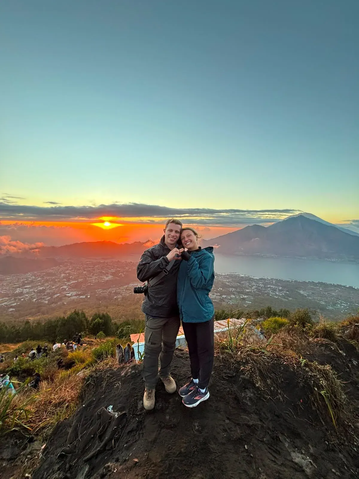 Guests at the Mount Batur summit at sunrise, Lake Batur behind them