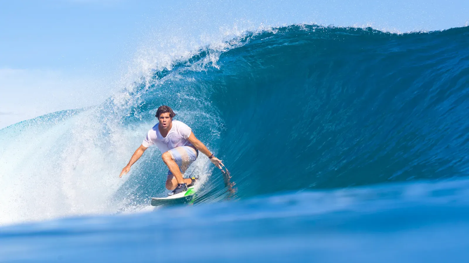 Surfer riding an ocean wave during a surf lesson in Nusa Dua Bali