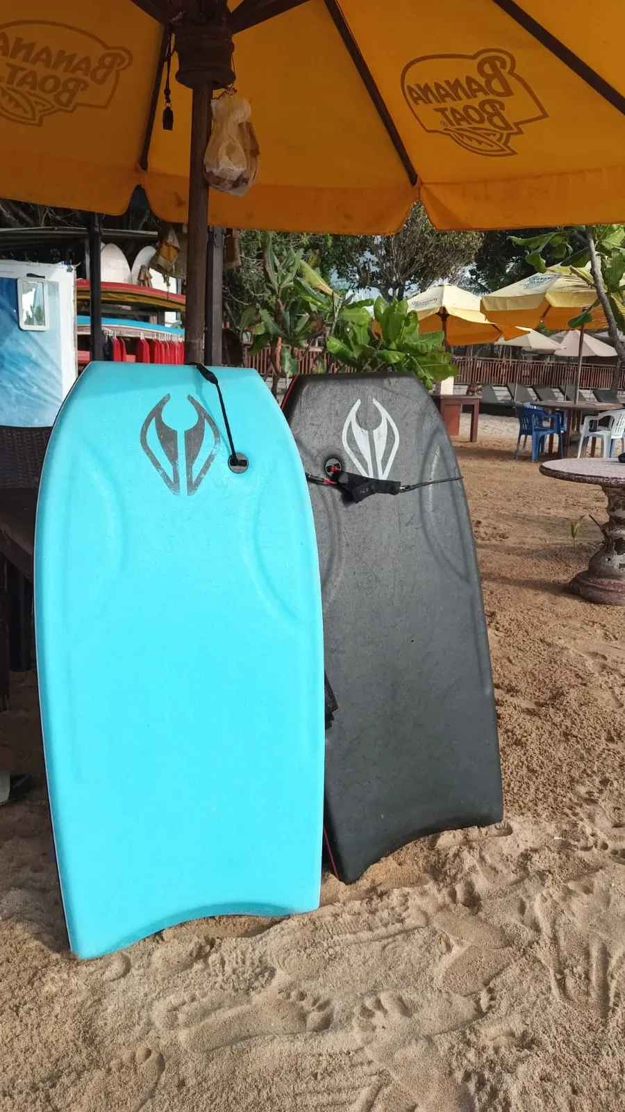 A surfboard carried along the wet sand of a beach