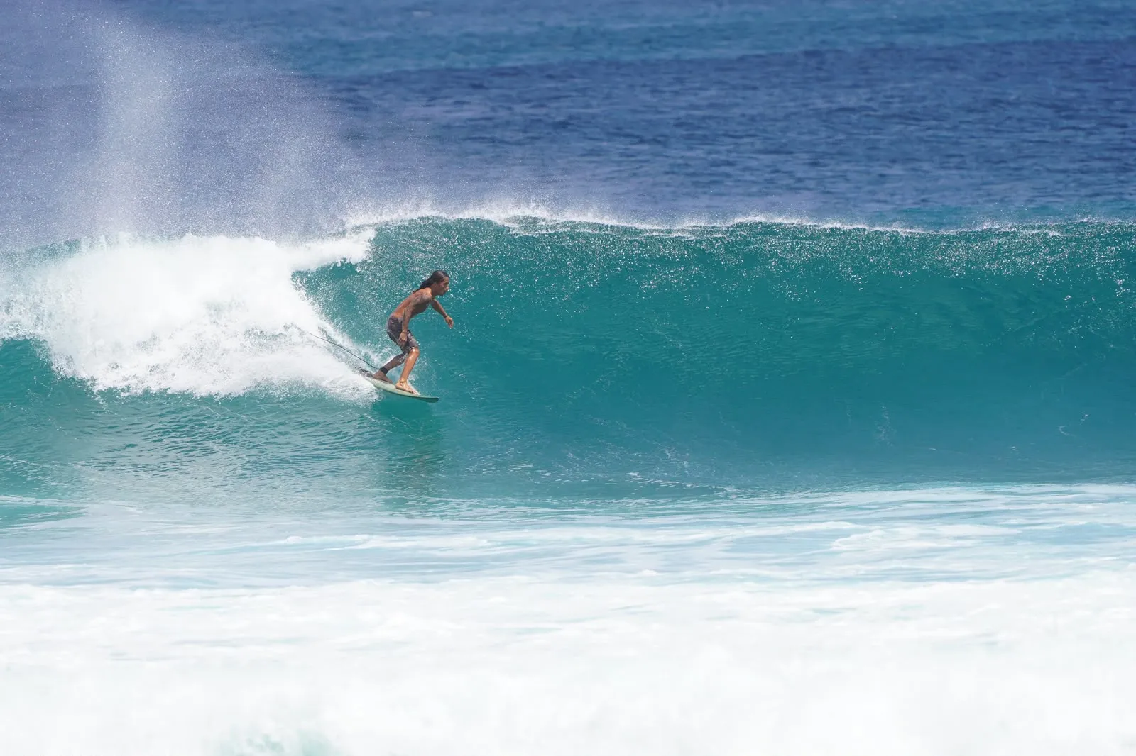 Surfer trimming along the face of a peeling wave