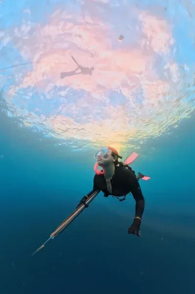 Snorkeler among a school of fish in Amed