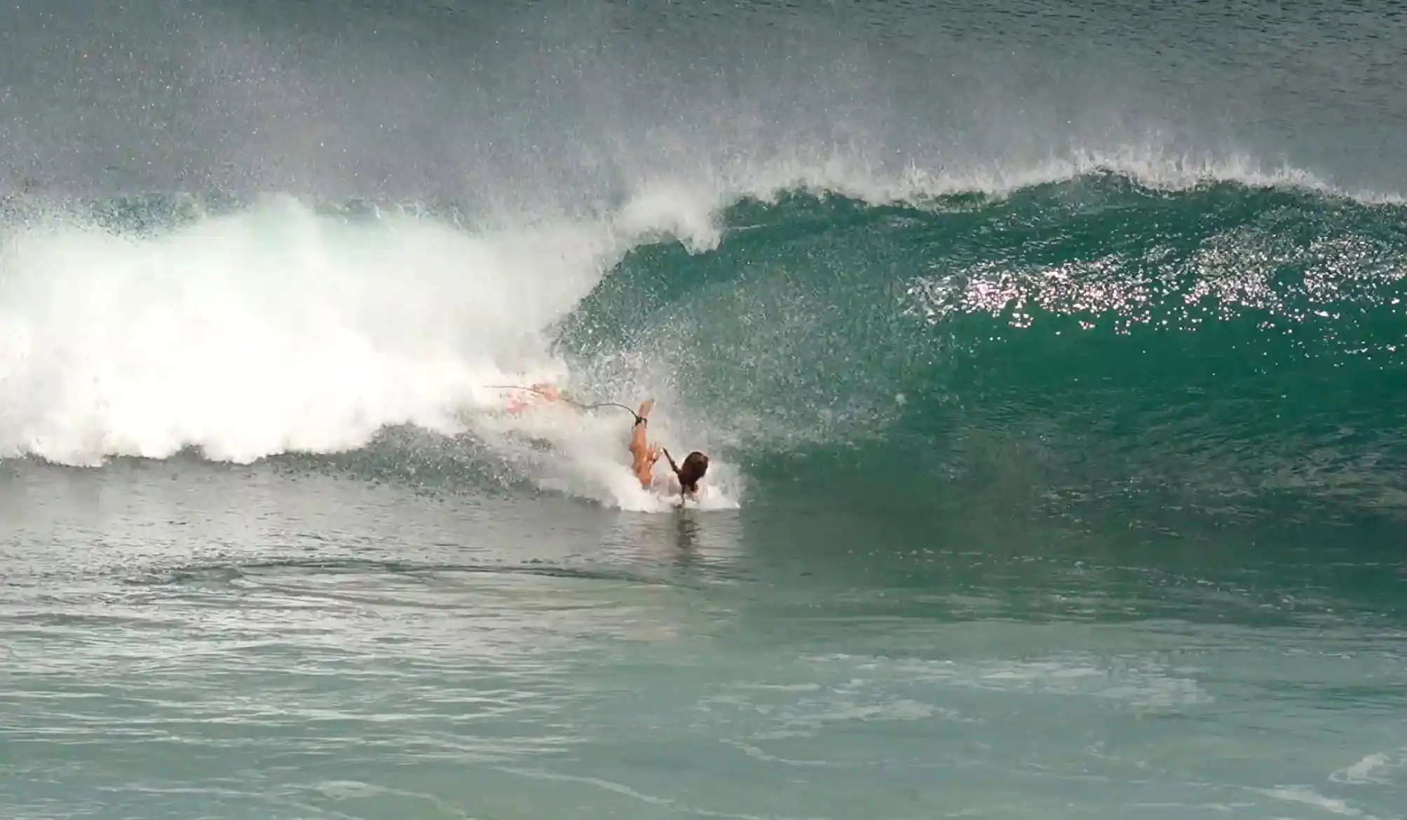 Surfer riding along the face of a breaking wave