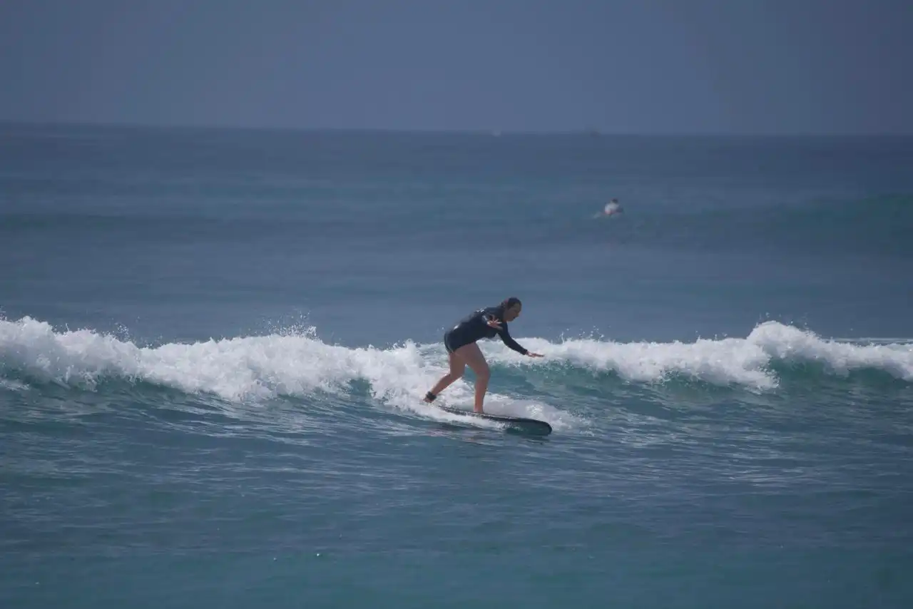 Two surfers paddling out on blue and orange boards
