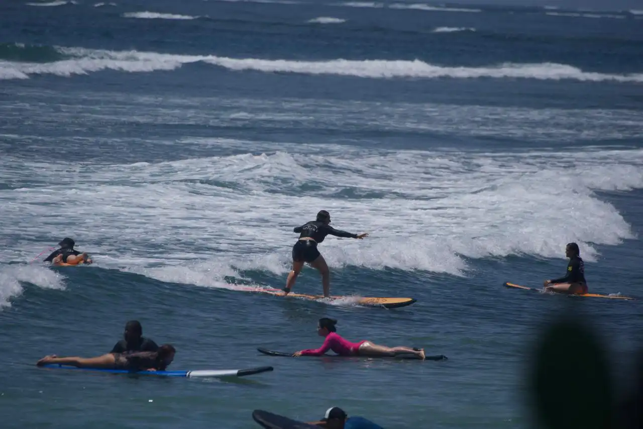 Surfers sitting on boards beyond a breaking wave